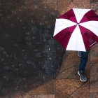 Una persona camina con una sombrilla bajo la lluvia (Archivo)