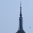 Two helicopters fly near the Empire State Building in New York on July 1, 2026. Two people climbed to the top of the Empire State Building on July 1 and unfurled a banner appearing to read "when the power of love beats the love of power the world knows peace," video published by US media showed. (Photo by TIMOTHY A. CLARY / AFP)