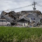 En la imagen se ve una casa derrumbada sobre un coche en Hikawa, en la prefectura de Kumamoto, el 30 de julio de 2026, tras el terremoto que sacudió la zona. El centro comercial Aeon de Kumamoto acababa de reabrir sus puertas en junio, reluciente, más resistente y seguro gracias a las últimas reformas realizadas tras los terremotos de 2016, con la promesa de ser un lugar donde las generaciones pudieran «compartir sonrisas». Sin embargo, a pesar de las exhaustivas obras de refuerzo realizadas en las instalaciones, que sufrieron graves daños hace una década, una explosión provocada por un nuevo terremoto el 28 de julio en la región suroeste de Japón las ha dejado en ruinas.