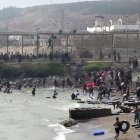 Esta captura de vídeo de AFP muestra a migrantes llegando a la costa del enclave español de Ceuta, en el norte de África, tras nadar alrededor de la valla fronteriza entre Marruecos y España, en Ceuta, el 30 de julio de 2026.