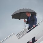 El presidente Donald Trump camina bajo un paraguas al desembarcar del Air Force One en la Base Conjunta Andrews, Maryland, el 2 de agosto de 2026.
