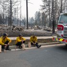 Tres miembros del Cuerpo de Bomberos de Spokane están sentados en el bordillo frente a unas viviendas calcinadas en el barrio de Balboa, en Spokane (Washington), el 2 de agosto de 2026. Los incendios, que avanzaron a gran velocidad, dejaron un rastro de destrucción el domingo en la ciudad de Spokane, situada en el noroeste de Estados Unidos; las autoridades informaron de que cientos de edificios quedaron reducidos a cenizas.