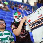 A fan of Santos Laguna wears a mask while holding up a jersey during a soccer match against Santos Laguna at Sports Illustrated Stadium in Harrison, New Jersey, on August 6, 2026. (Photo by Gordon Donovan/NurPhoto) (Photo by Gordon Donovan / NurPhoto via AFP)