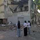 Mujeres miran un edificio caído tras el sismo en Colombia