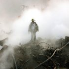 Un bombero camina entre los escombros y los restos humeantes del World Trade Center el 11 de octubre de 2001 en Nueva York. Se celebró una ceremonia interreligiosa en la Zona Cero con motivo del primer mes desde los atentados, que se conmemoró con un breve servicio religioso y un minuto de silencio a las 8:48 de la mañana.