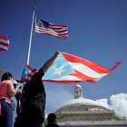 Imagen de archivo y de referencia que muestran manifestantes con la bandera de Puerto Rico