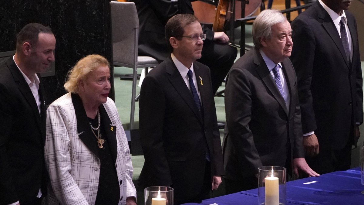 El presidente israelí Isaac Herzog (centro) con el secretario general de la ONU António Guterres y la sobreviviente del Holocausto Marianne Muller