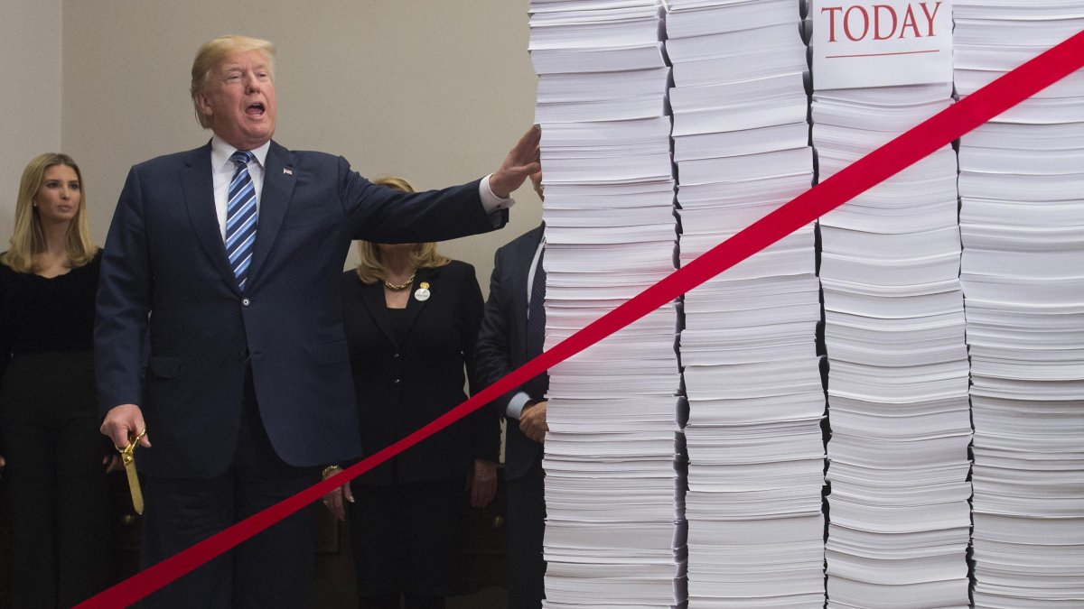 Donald Trump with gold scissors in hand during his first term.