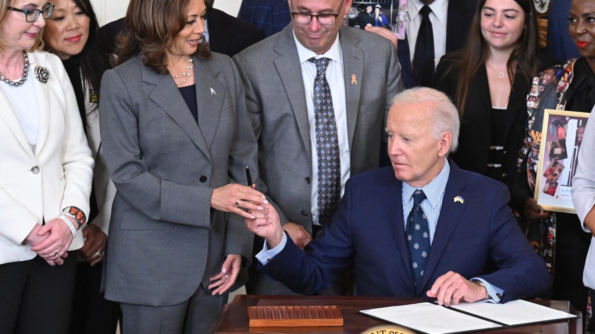 Biden and Kamala hold up the pen after the president signed a bill into law