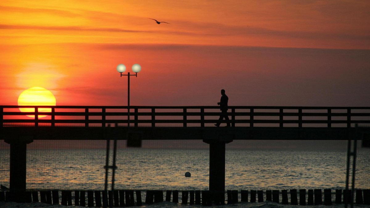 A lonely man walks along a pier-File Image.