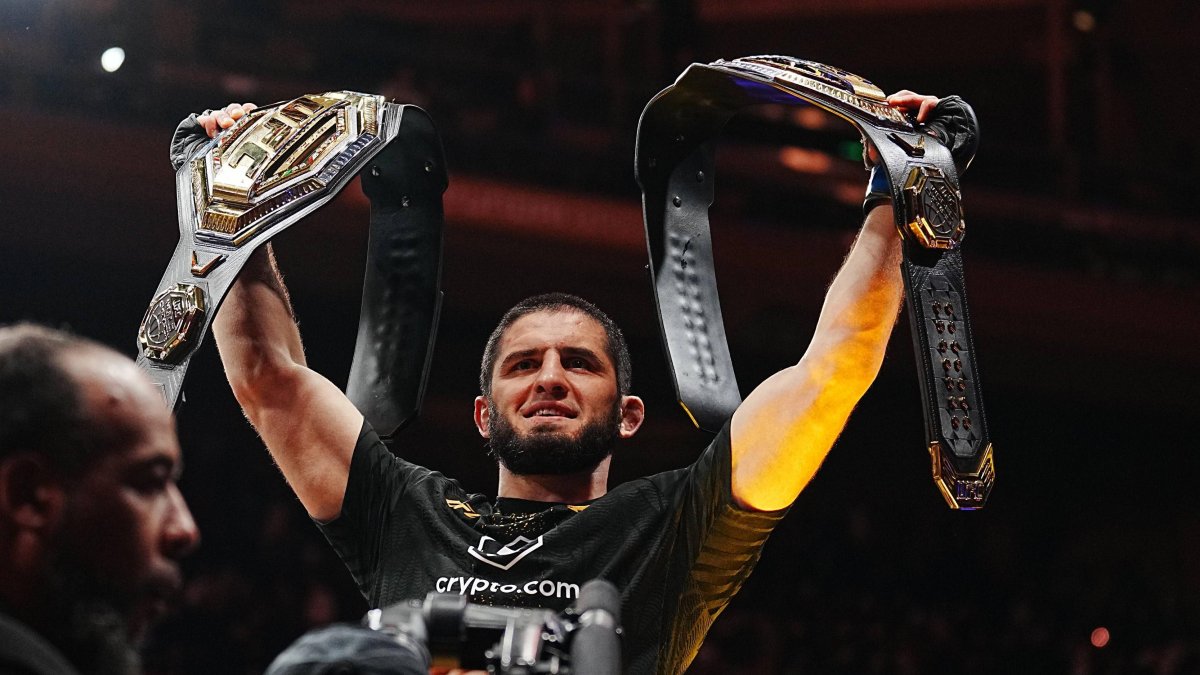 Islam Makhachev alza sus dos cinturores de campeón.