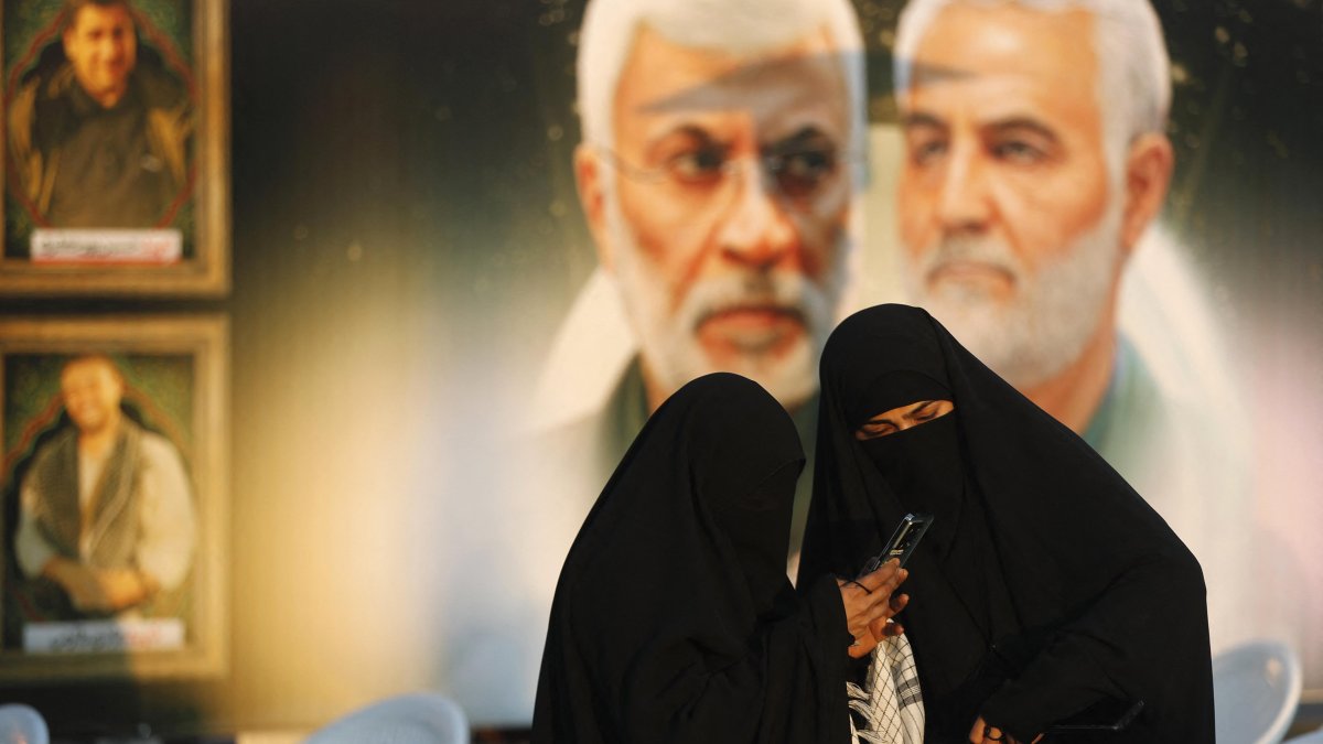Women in front of portraits of Iranian Revolutionary Guard commander Qasem Soleimani.