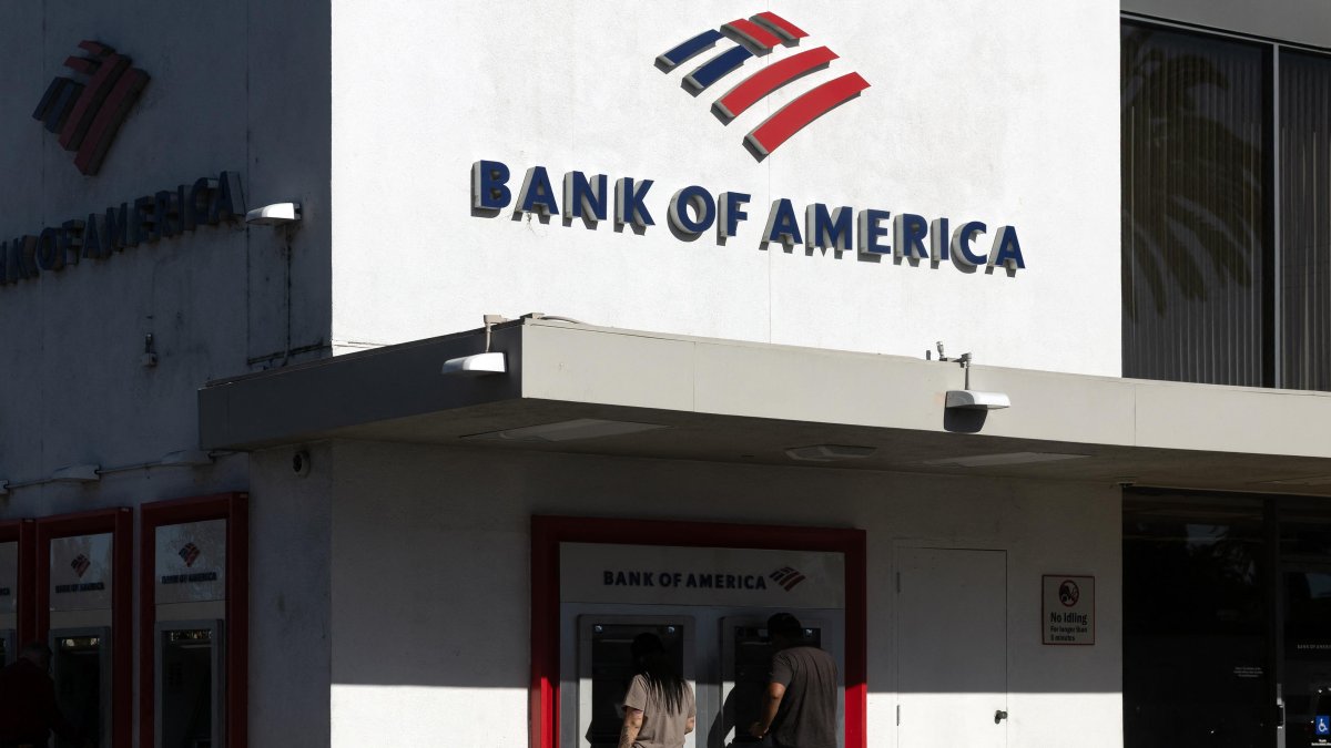 People use ATMs at a Bank of America branch