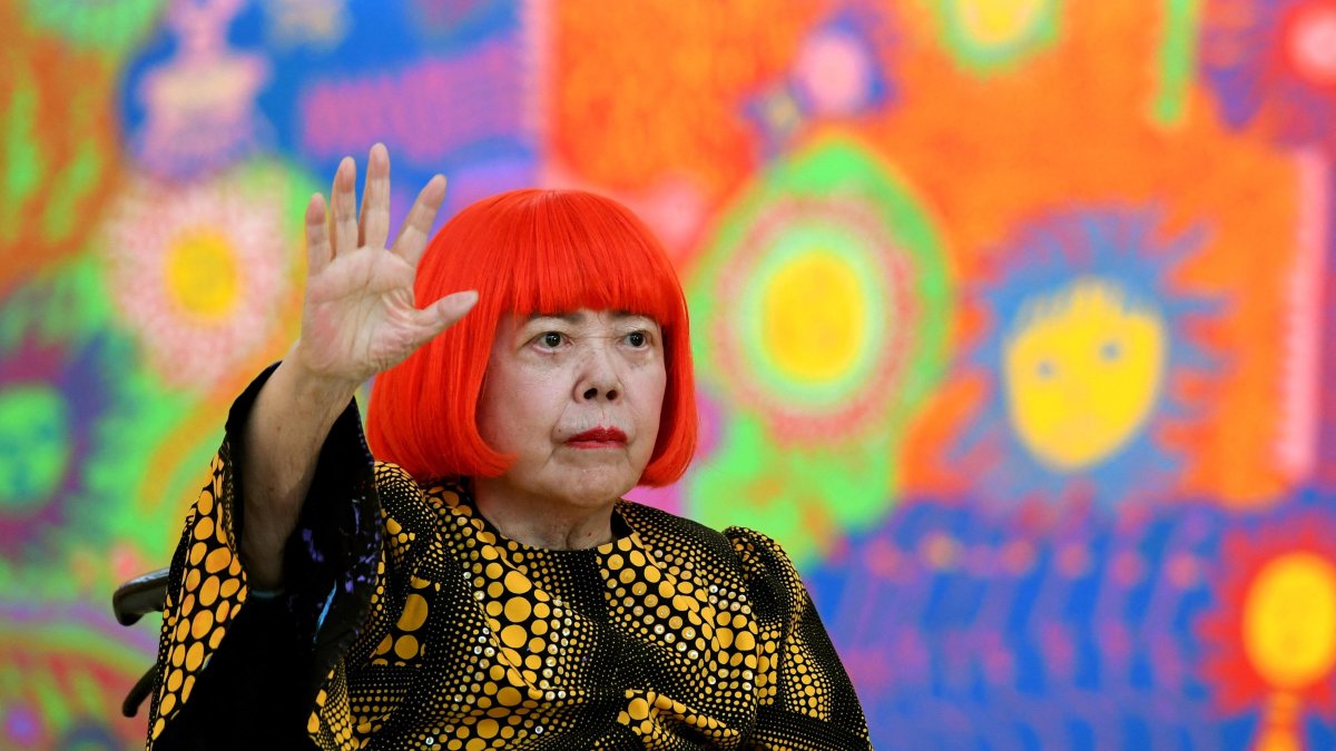 La artista japonesa Yayoi Kusama saluda durante una sesión fotográfica (Archivo)