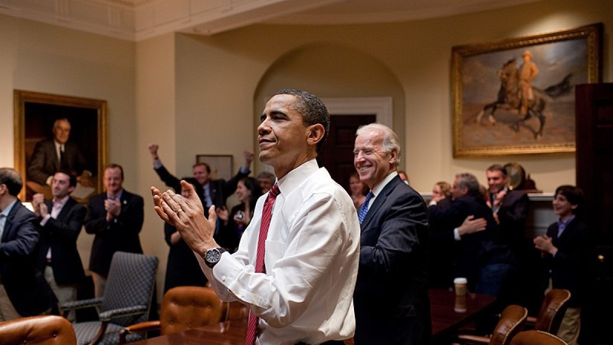 President Barack Obama, Vice President Joe Biden, and senior staff applaud in the Roosevelt Room of the White House, as the House passes the health care reform bill, March 21, 2010. (Official White House Photo by Pete Souza)..This official White House photograph is being made available only for publication by news organizations and/or for personal use printing by the subject(s) of the photograph. The photograph may not be manipulated in any way and may not be used in commercial or political materials, advertisements, emails, products, promotions that in any way suggests approval or endorsement of the President, the First Family, or the White House.