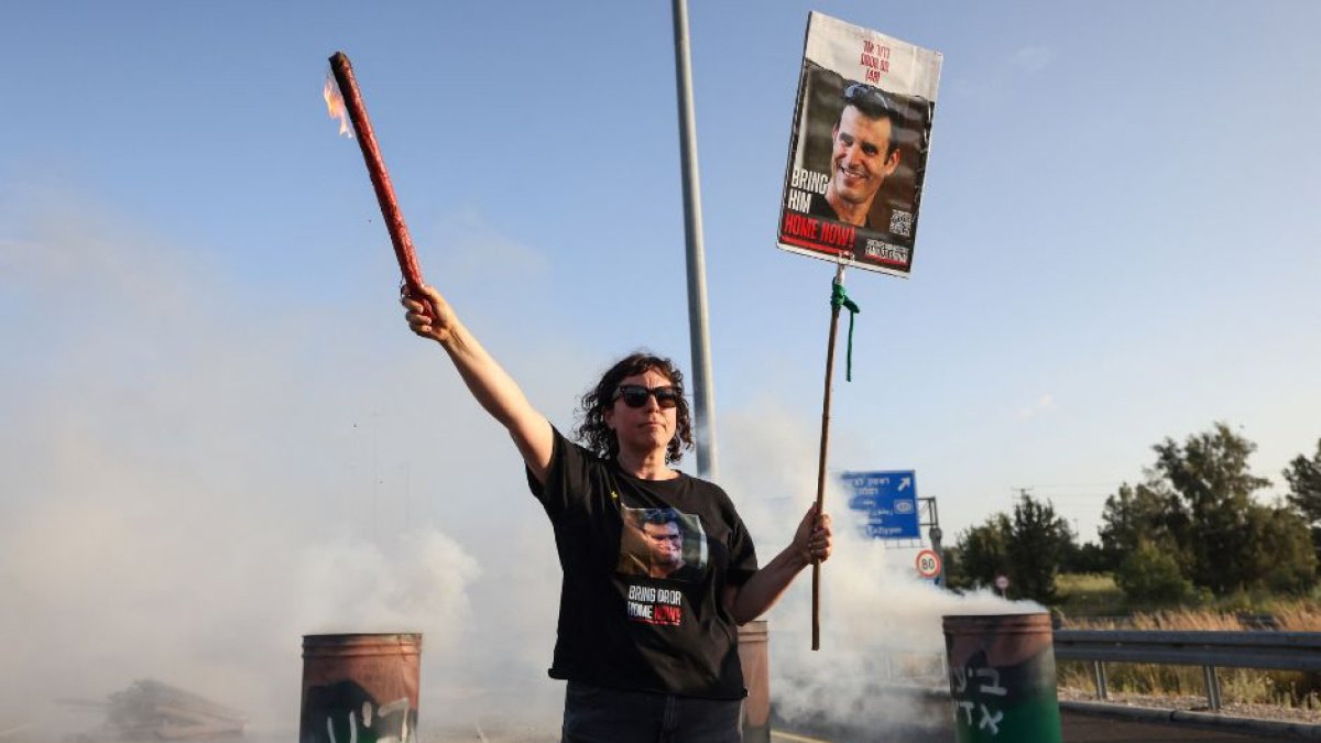 Una mujer sostiene un cartel con la imagen del rehén israelí Dror Or, asesinado por Hamás. (AFP)