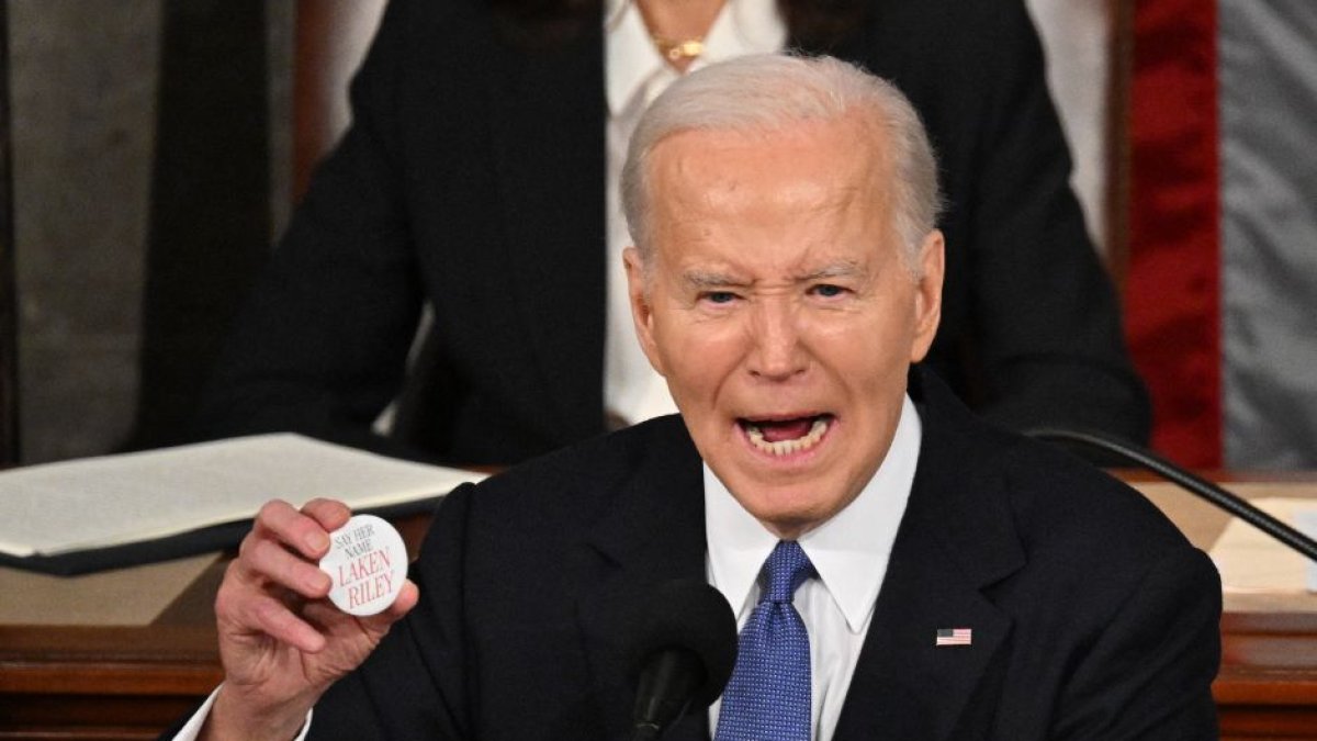 Joe Biden sostiene un pin que dice 