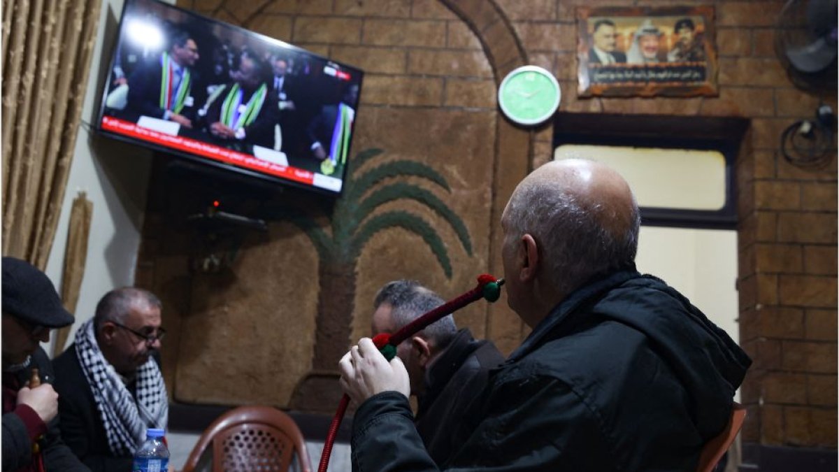 Hombres observan en un café el veredicto de la Haya (Photo by Jaafar ASHTIYEH / AFP)