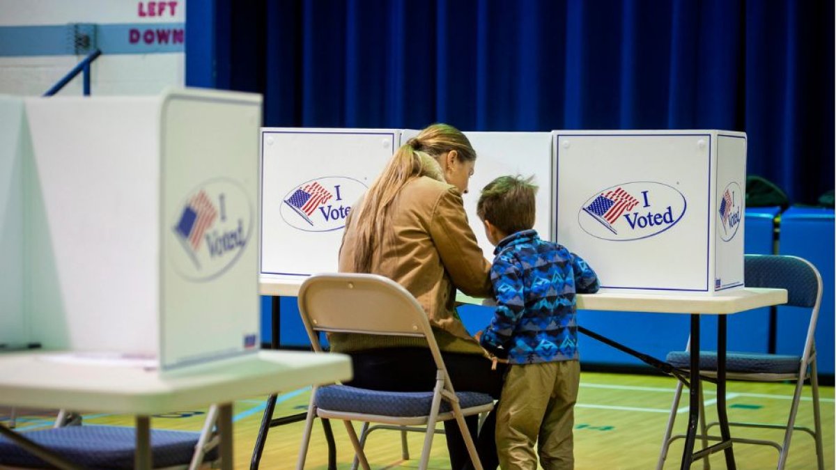 Una mujer vota junto a un niño en una imagen de
