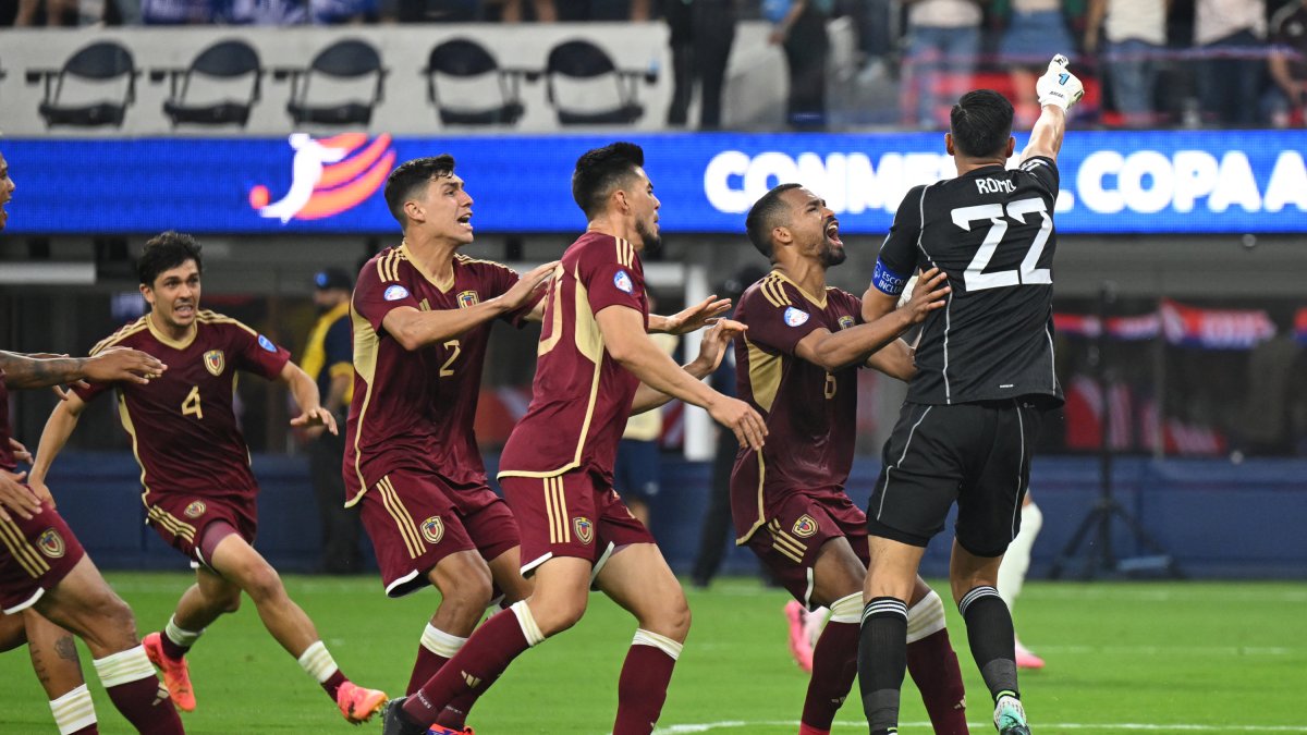 Los jugadores venezolanos celebran con el arquero Rafael Romo, quien detuvo un penal sobre el final del partido