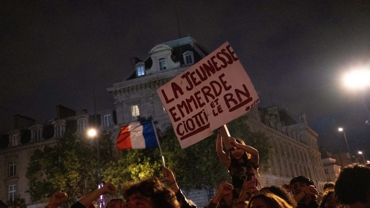 A boy holds a banner which says 