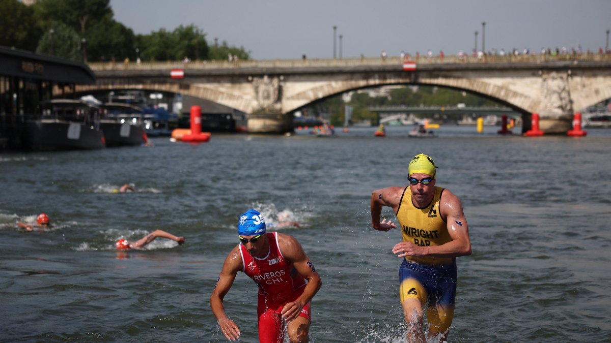 Olympic athletes exit the Seine River in Paris/Christine Poujoulat