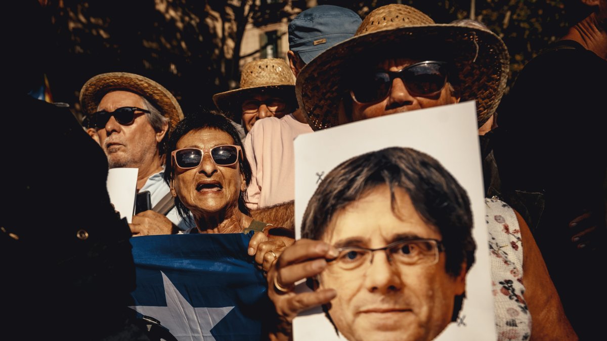 Manifestantes con una careta de Puigdemont.