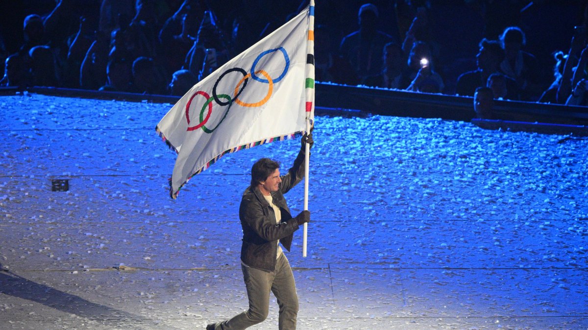 Tom Cruise waves the Olympic flag during the closing ceremony of the Paris 2024 Olympics.