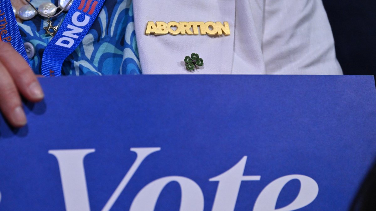 Un asistente lleva un pin de 'Aborto' en el primer día de la DNC 2024