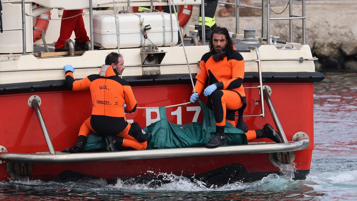 Italian authorities bring one of the bodies that was on the wrecked superyacht 'Bayesian' to the dock.