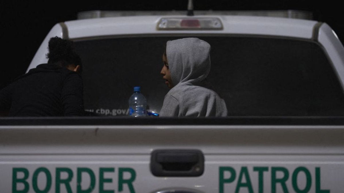 Joven migrante sentado en la parte trasera de una camioneta de la Patrulla Fronteriza