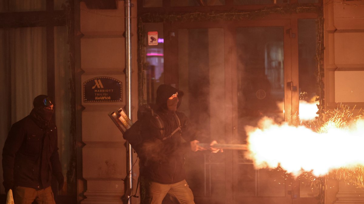 A protester throws fireworks at police in Tbilisi.