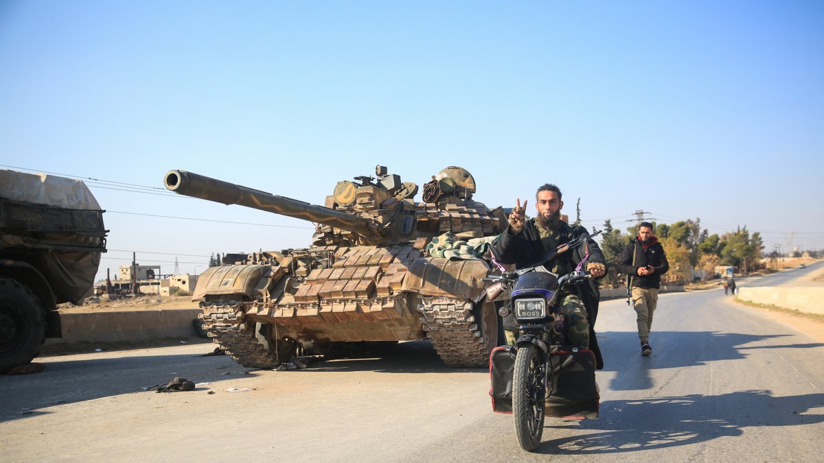 Rebeldes yihadistas junto a equipamiento militar abandonado por las fuerzas del Gobierno sirio