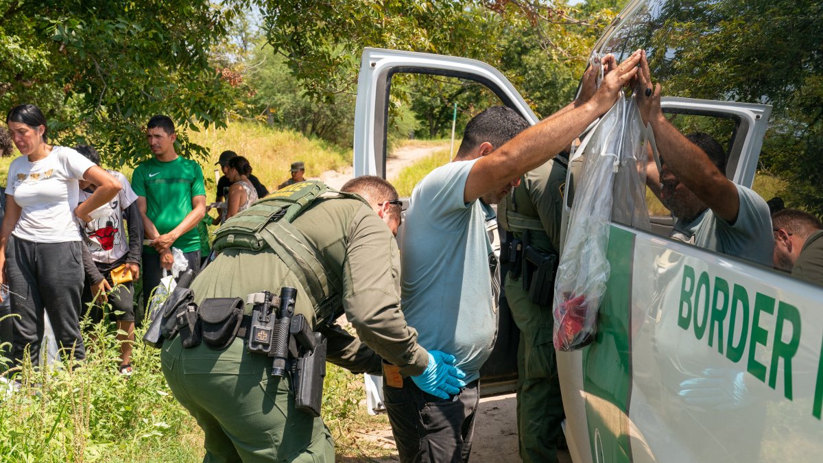 Border Patrol agent patting down an immigrant