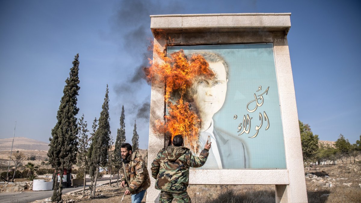 Un sirio quema una imagen del expresidente Bashar Asad