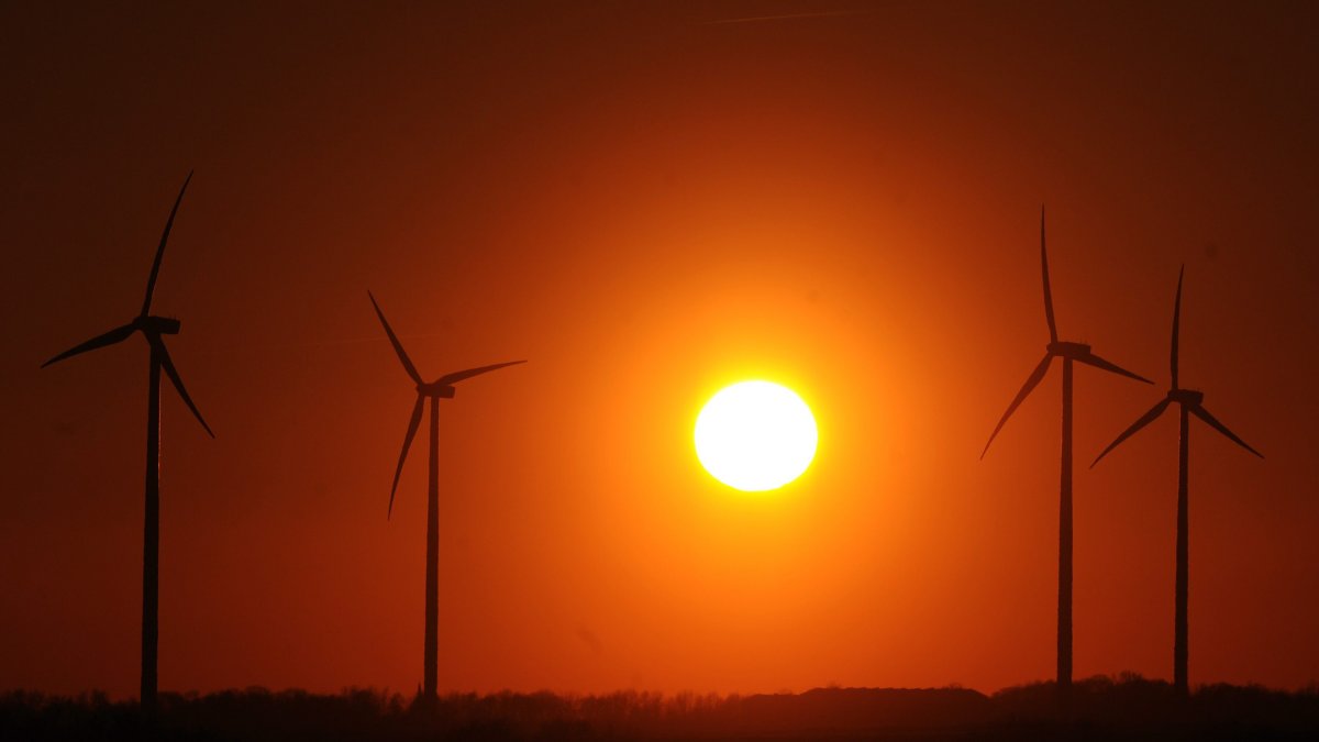 The sun sets behind wind turbines at the windpark Bedburg, Germany