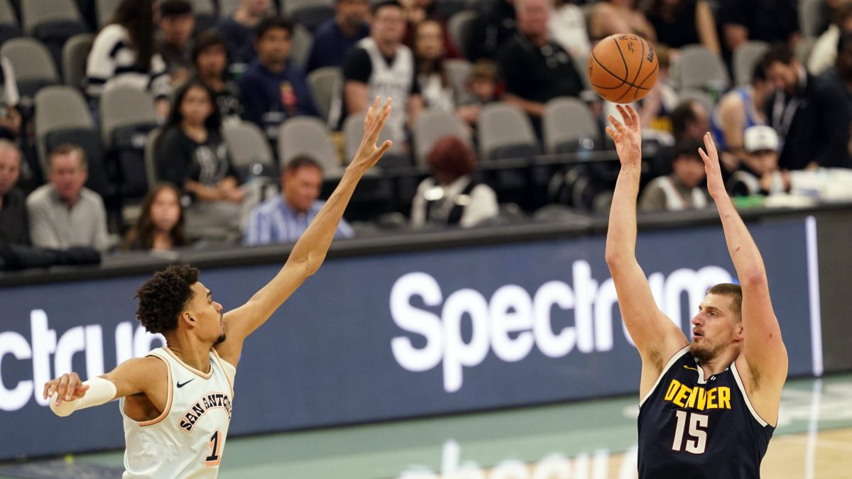 Nikola Jokic lanza el balón por encima de Victor Wembanyama