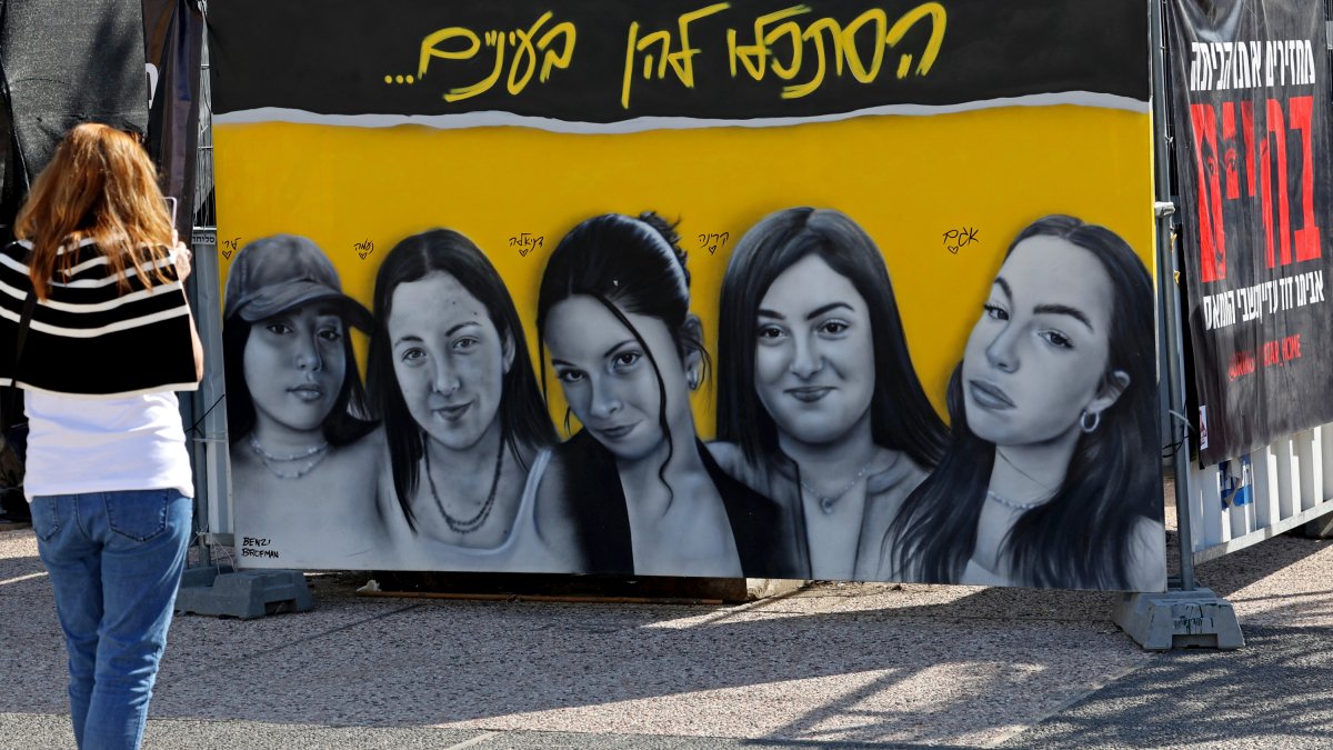 A woman looks at the portraits of five Israeli female hostages placed in Hostages Square in Tel Aviv, Israel.