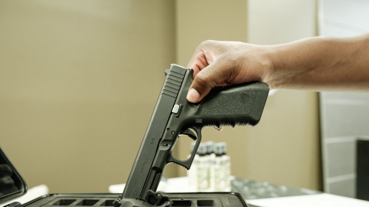 Una pistola siendo guardada-Imagen de Archivo