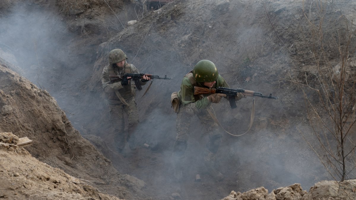 Civiles participan en un entrenamiento de guerra de trincheras durante una 