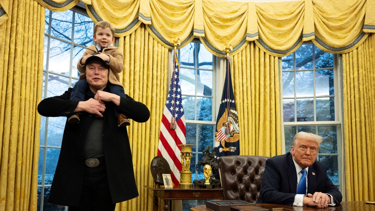 Elon Musk (with his son on his shoulders) in the Oval Office next to President Trump