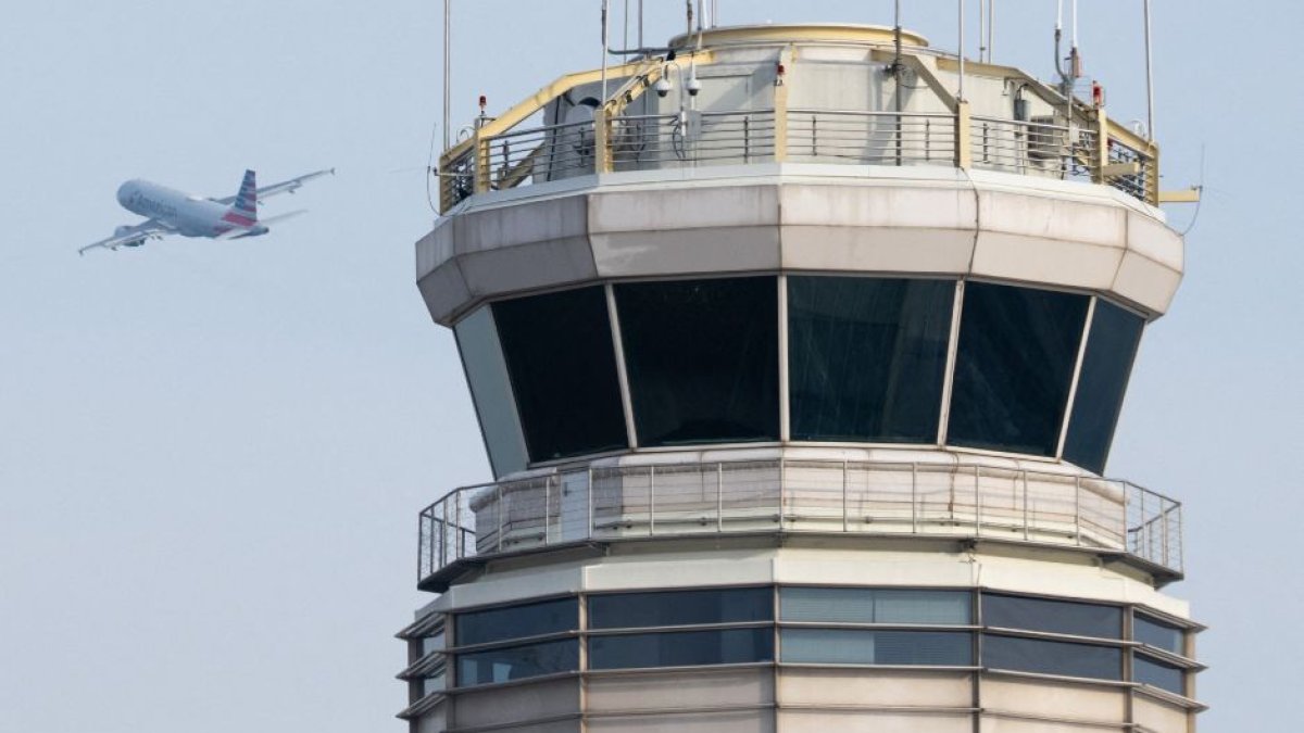 Un avión despega frente a la torre de control de tráfico aéreo