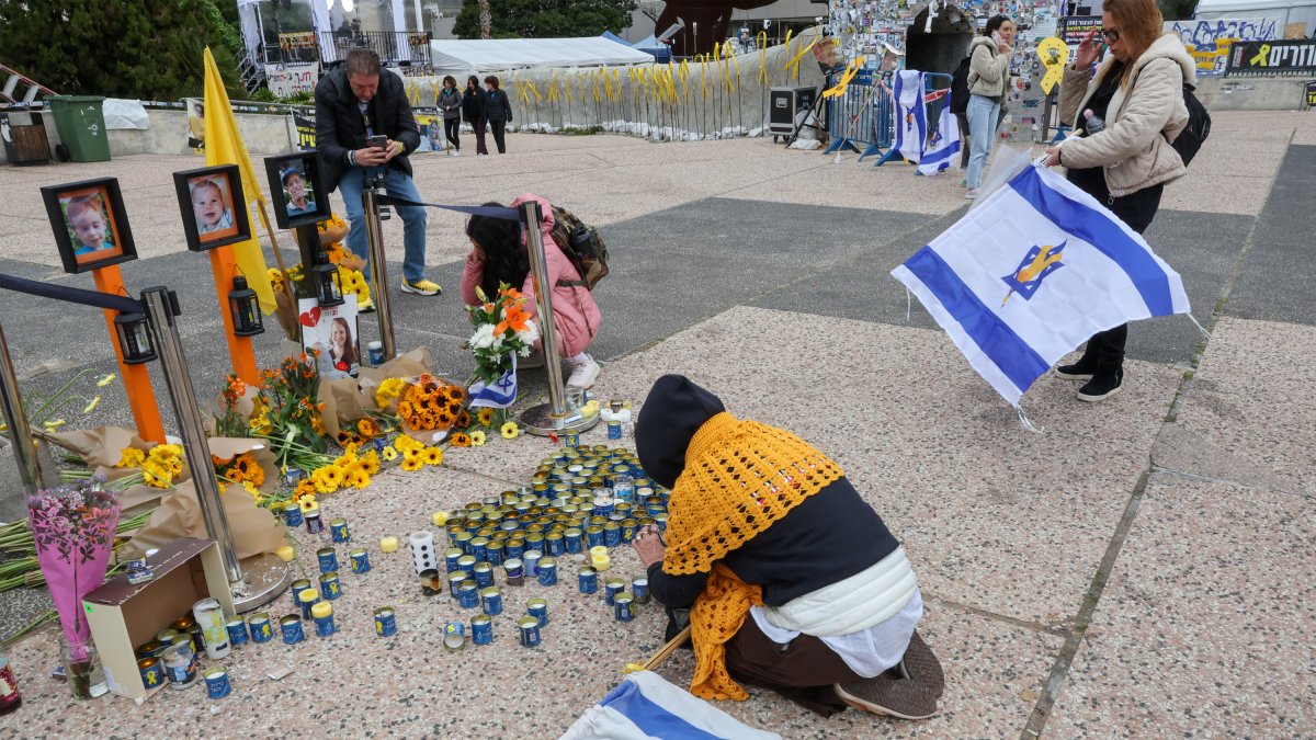 Una mujer enciende una vela en memoria de los rehenes israelíes fallecidos