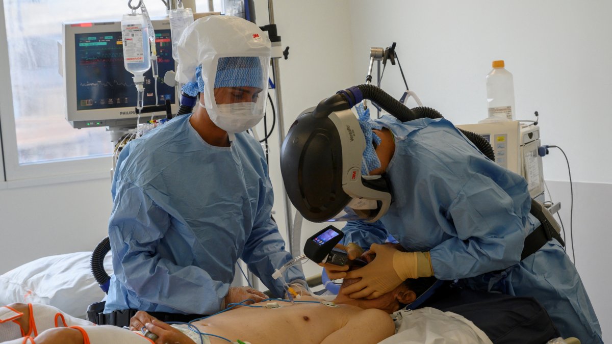 Un médico realiza una intubación para ventilación mecánica a un paciente con covid