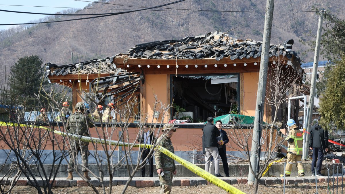 Authorities inspect a damaged house after a bomb crash