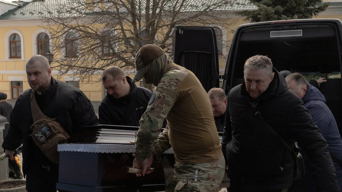 Ukrainian soldiers carry the coffin of a comrade