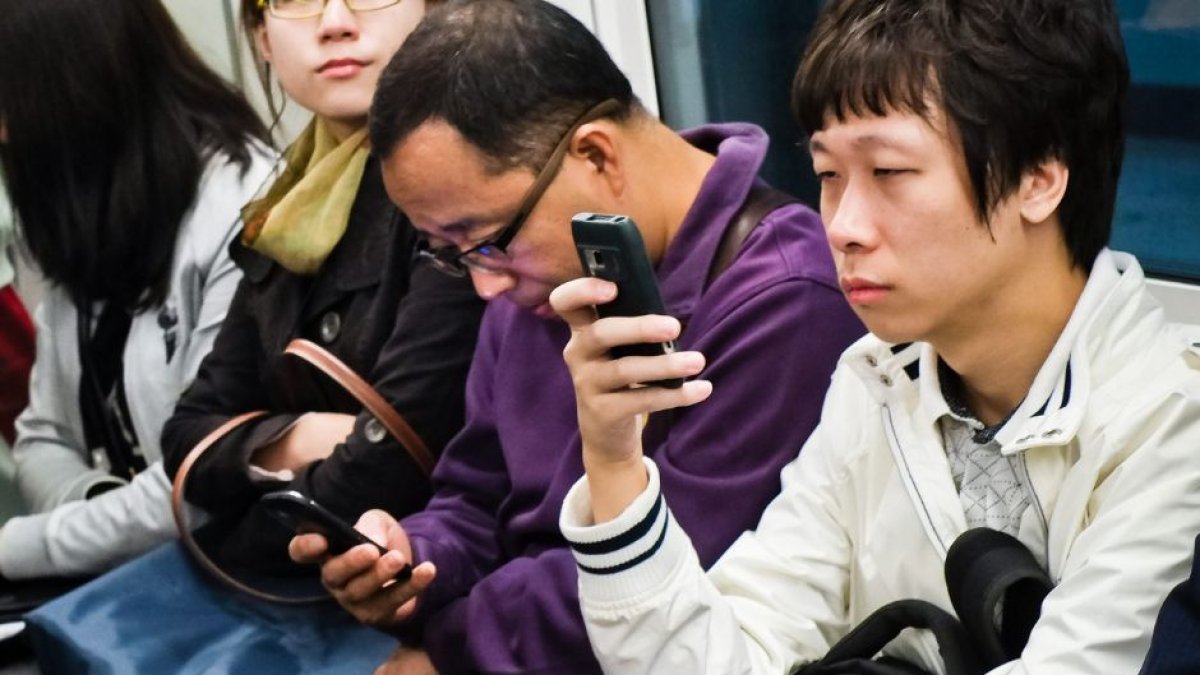 Chinese citizens looking at their phones