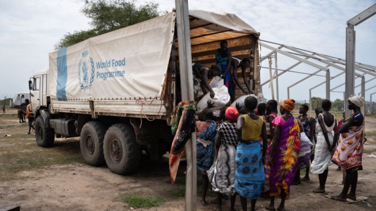 Mujeres descargan sacos de un camión del Programa Mundial de Alimentos (PMA)