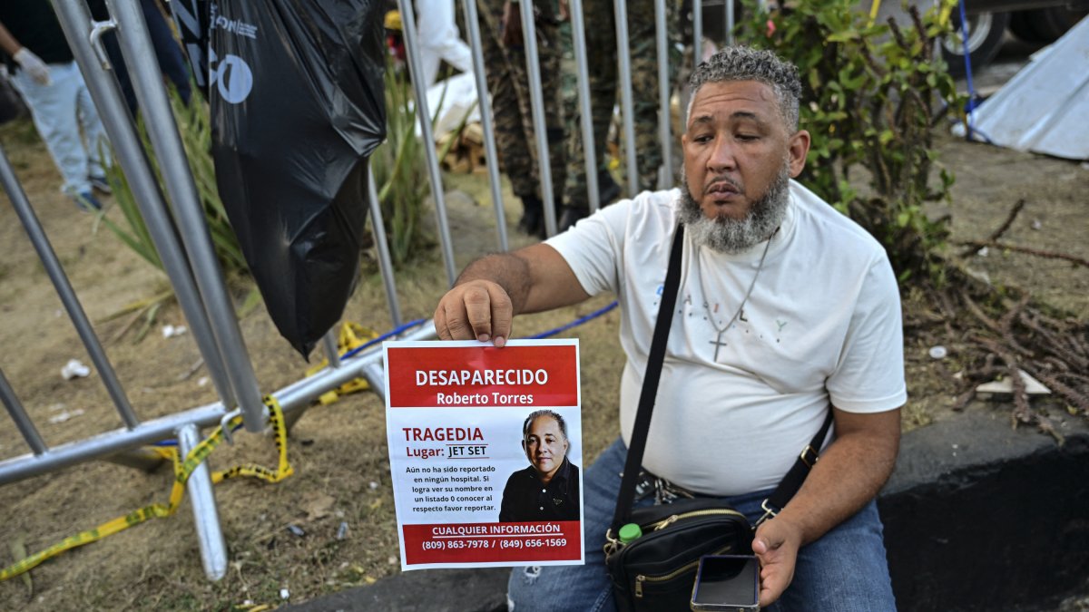 Un hombre sostiene una foto de un familiar desaparecido en la discoteca Jet Set tras el derrumbe de su techo en Santo Domingo.