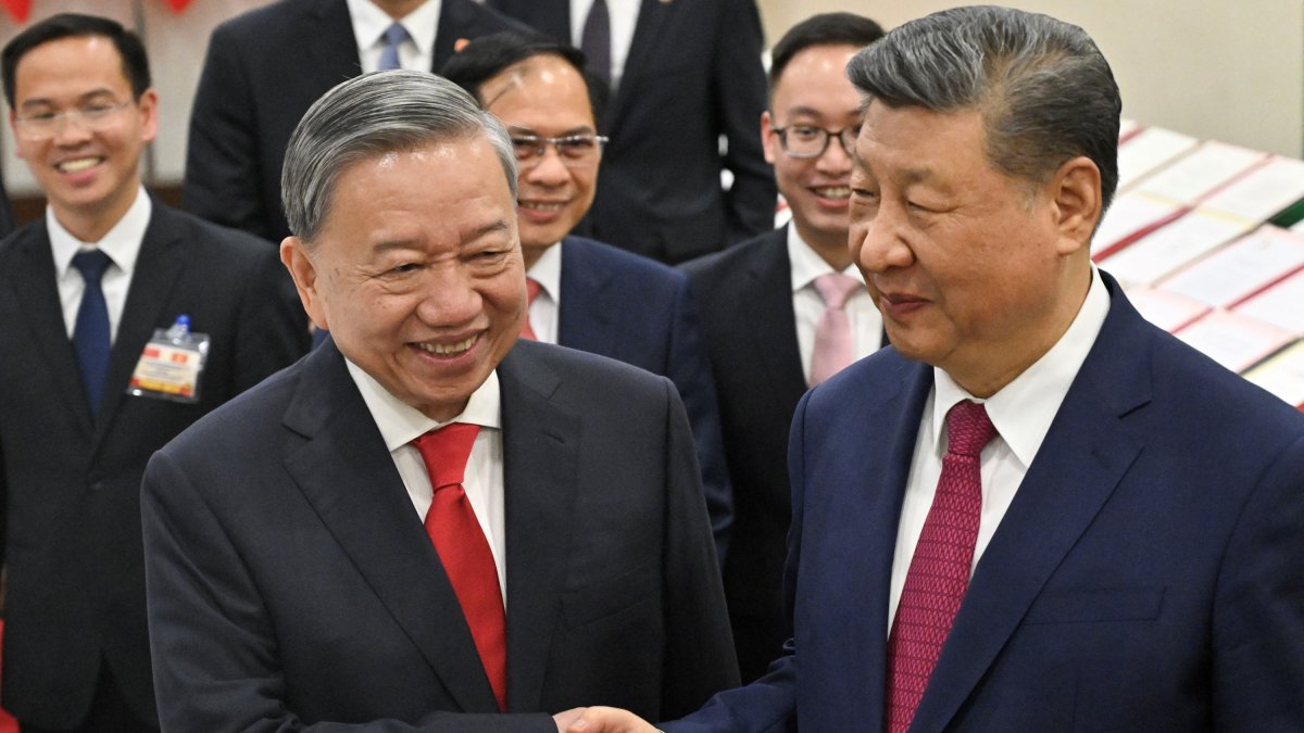 El secretario general del Partido Comunista de Vietnam, To Lam (izda.), y el presidente chino, Xi Jinping, se dan la mano